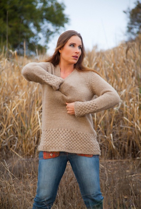 Curvy Vassanta peels off her jeans in a field to show a hairy pussy