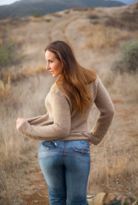 Curvy Vassanta peels off her jeans in a field to show a hairy pussy