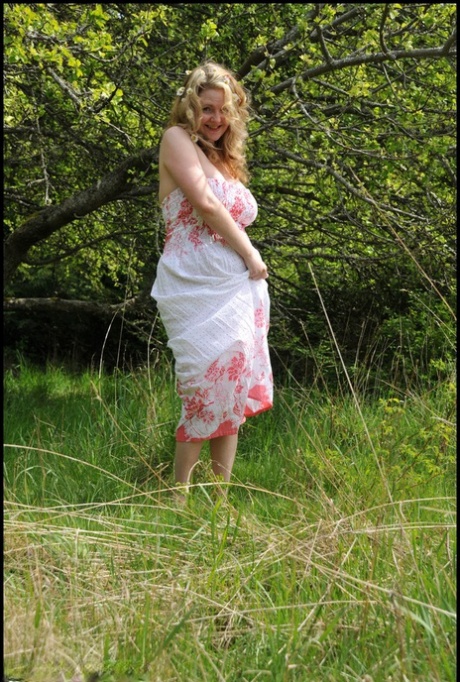 Mature amateur Tasty Trixie sets her big tits and bald twat loose under a tree