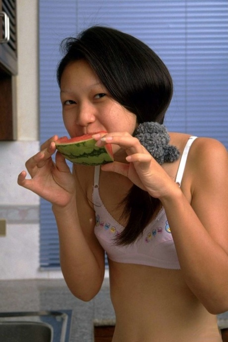 Petite Asian girl spreads her tight pussy after eating watermelon