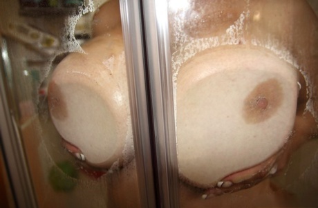 Plump solo girl plays with her hooters while taking a shower