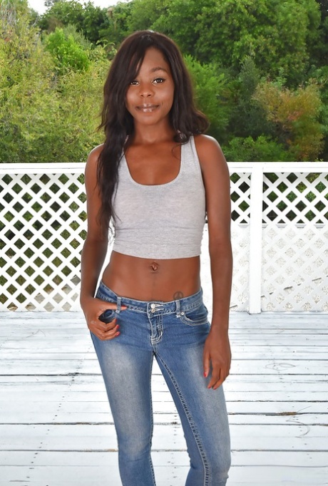 Ebony babe freeing sexy MILF ass and shaved cunt from denim jeans outdoors