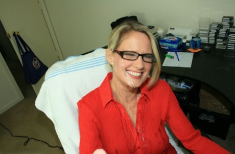 Fully clothed mature blonde in glasses gives a handjob and gets bukkaked