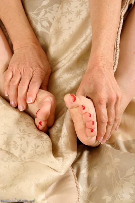 Petite mature woman Robin touches and licks her sexy painted toes