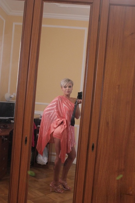 Short-haired stunner Oxy Summer poses provocatively in her sexy long dress