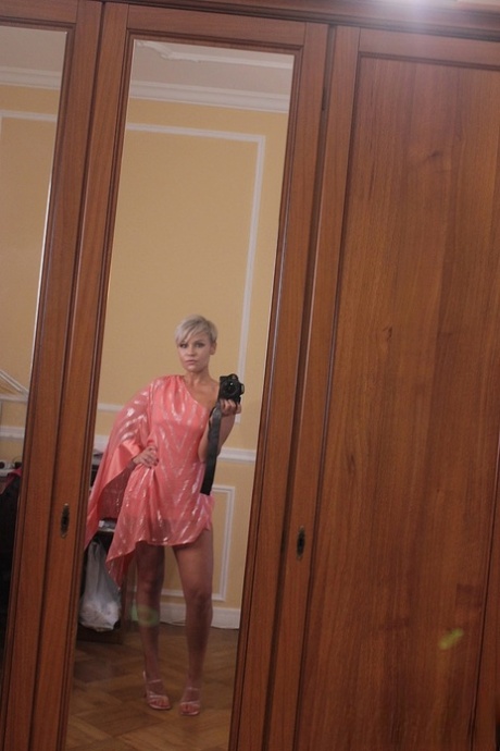 Short-haired stunner Oxy Summer poses provocatively in her sexy long dress