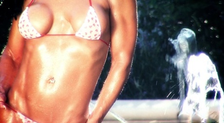 Kinky MILF with amazing muscular body Tracy Daniels poses in a tiny bikini